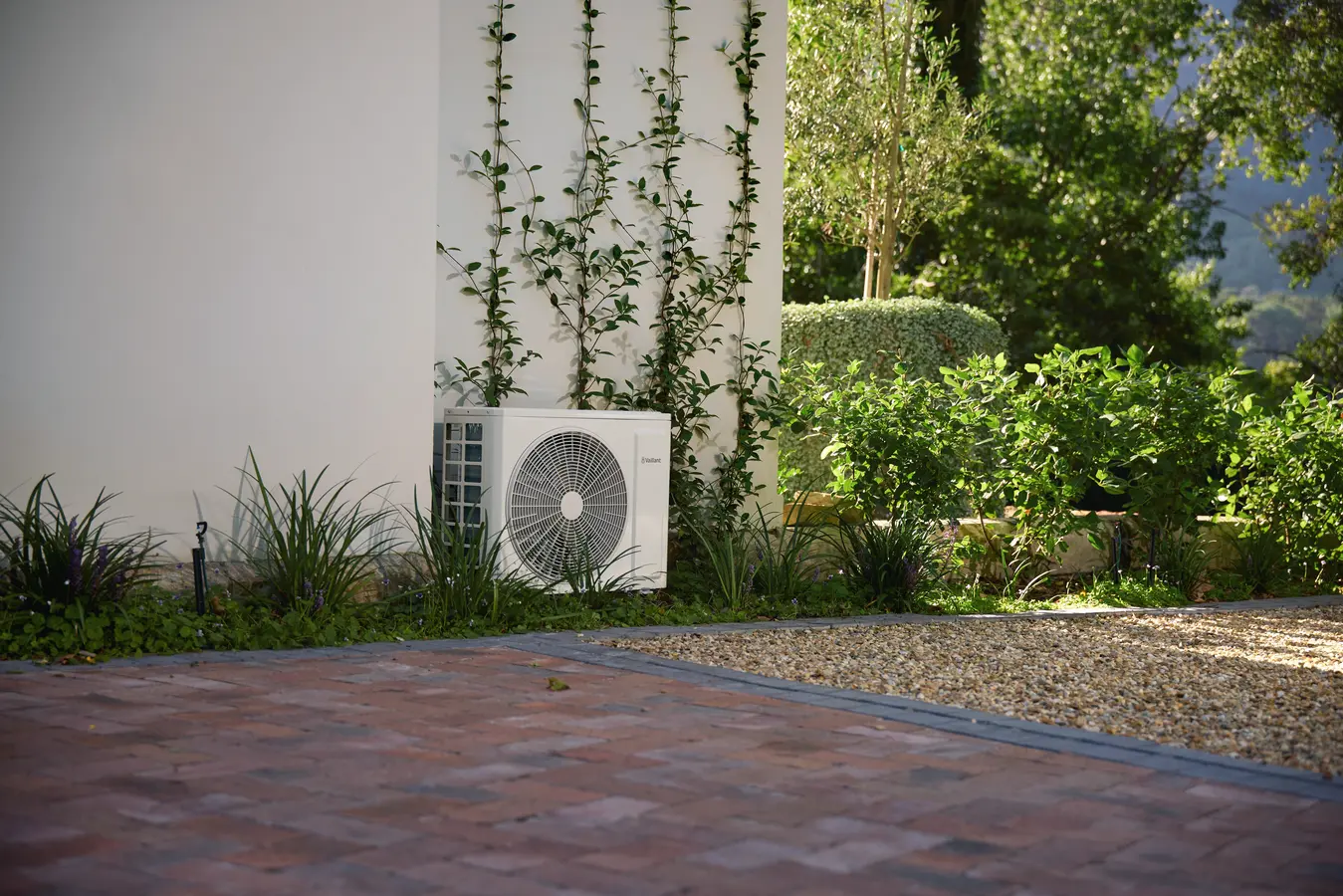Vaillant Klima-Außengerät an einer Hauswand im Garten