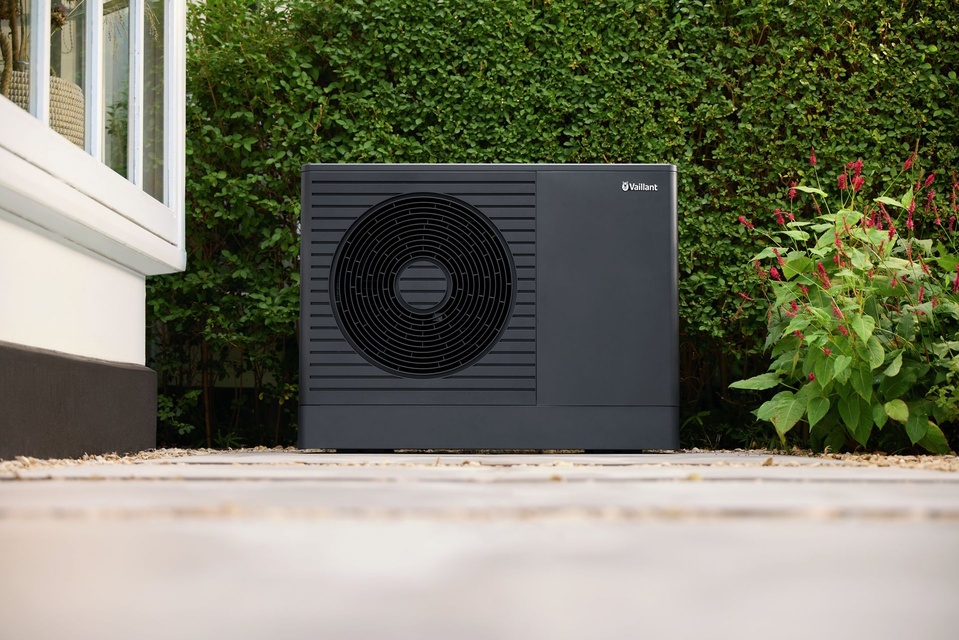 Vaillant aroTHERM plus frontal vor einer Hecke (Herstellerfoto)